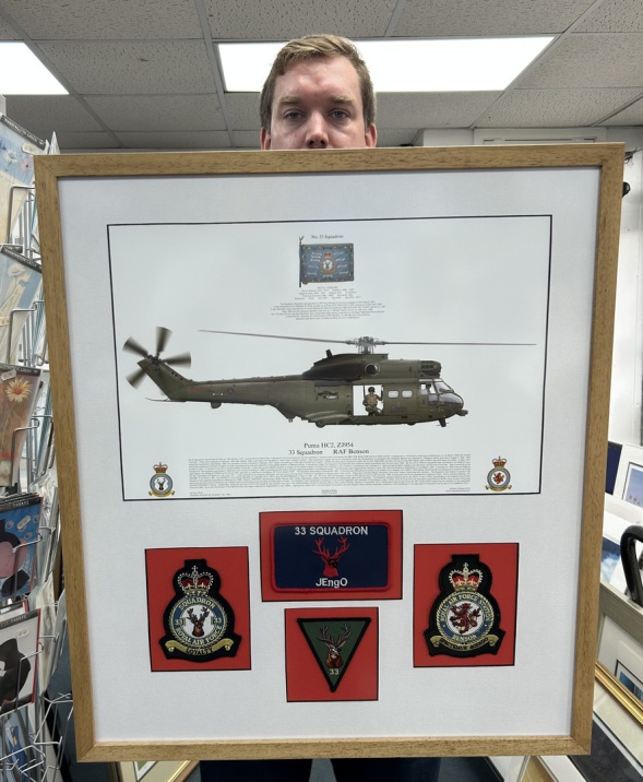 Imaginations fine arts. Customer with mounted memorabilia print and badges